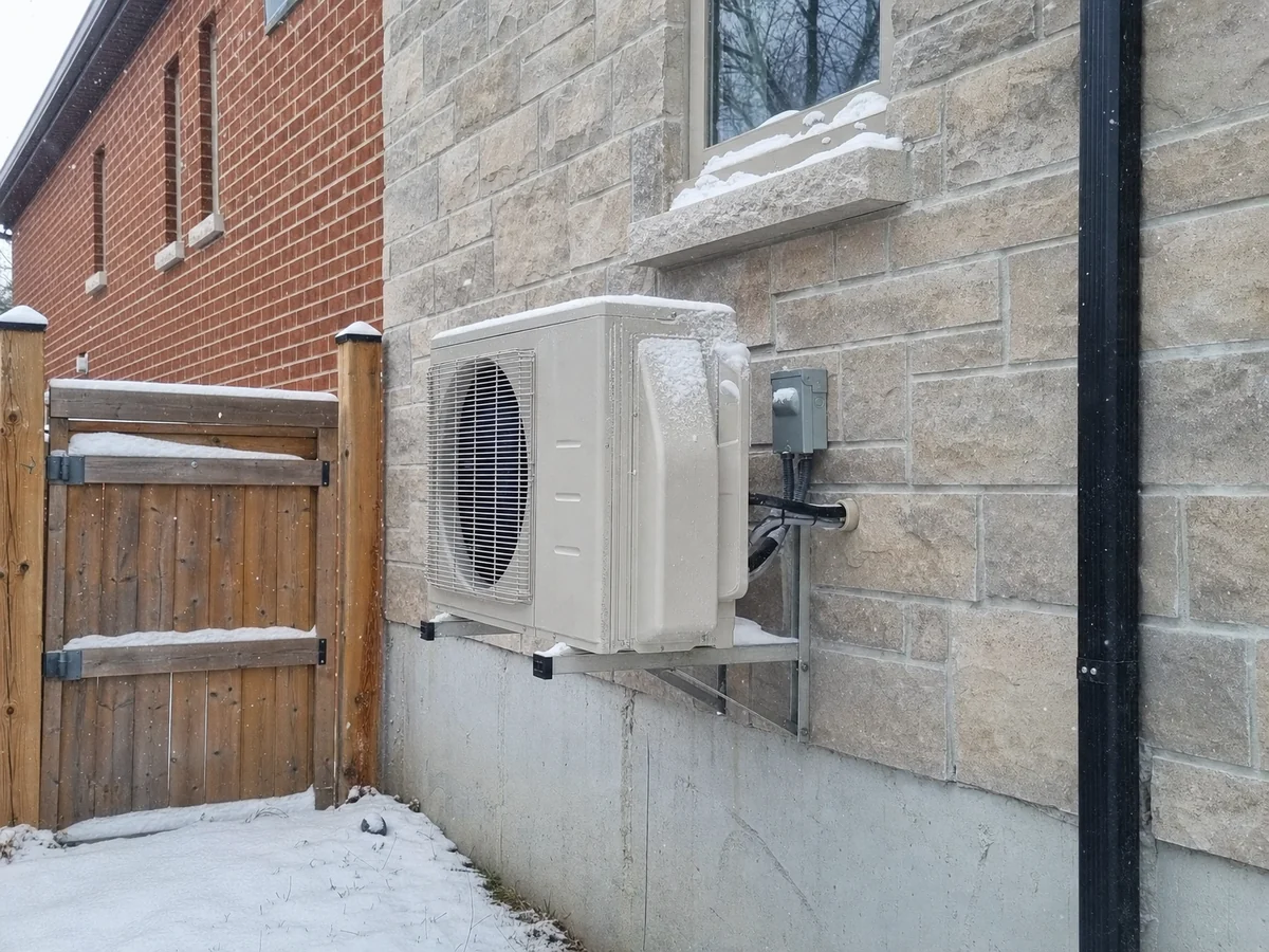 Cold-climate heat pump mounted above the snow line on a Toronto home