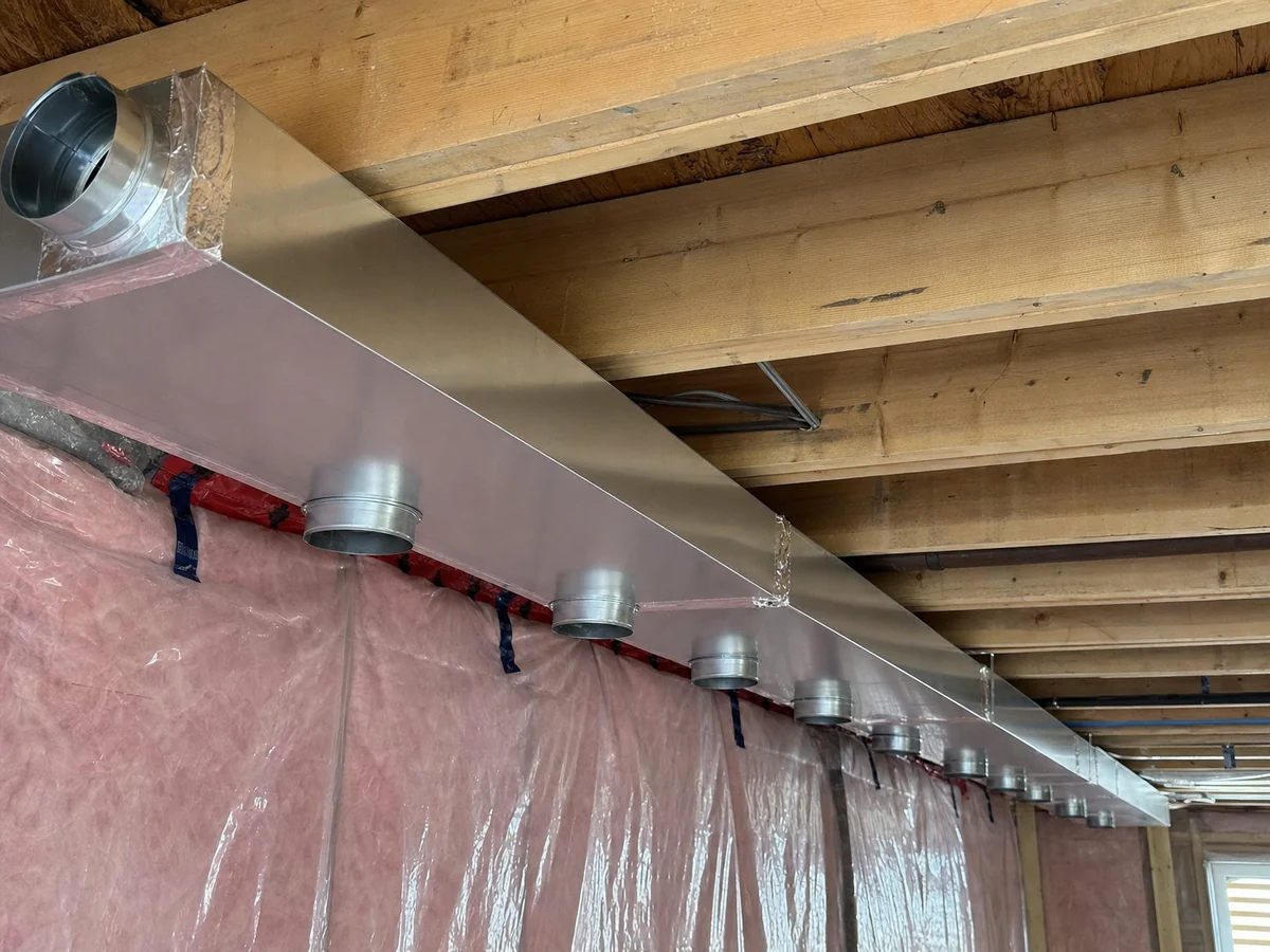 New sheet-metal trunk duct with foil-taped seams and branch takeoffs