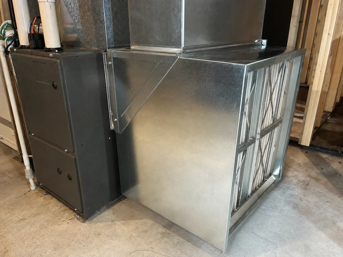 Galvanised return-air duct and filter rack connected to a furnace